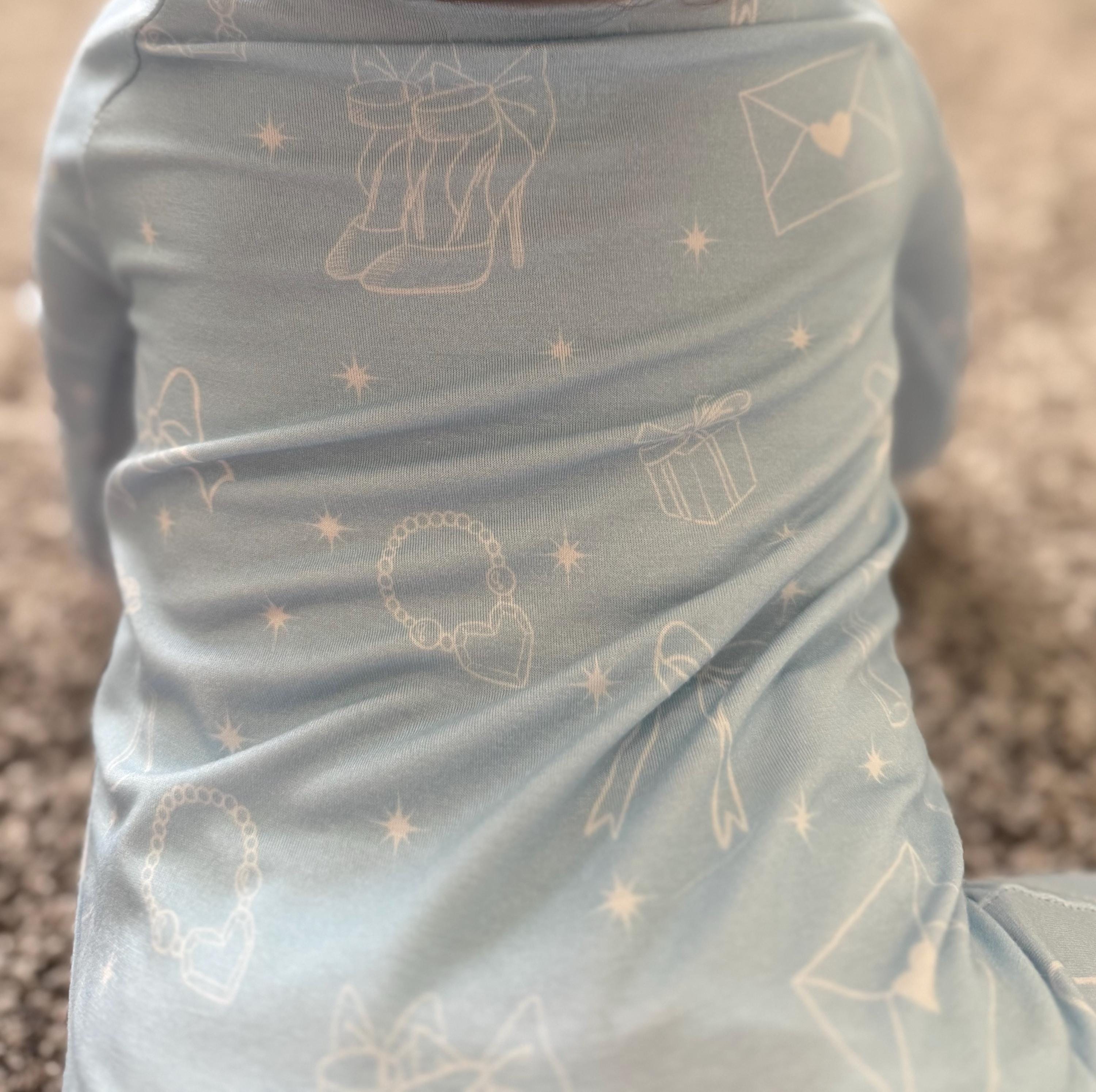 Baby wearing light blue bamboo pajamas with white girly designs on stretchy and soft fabric.