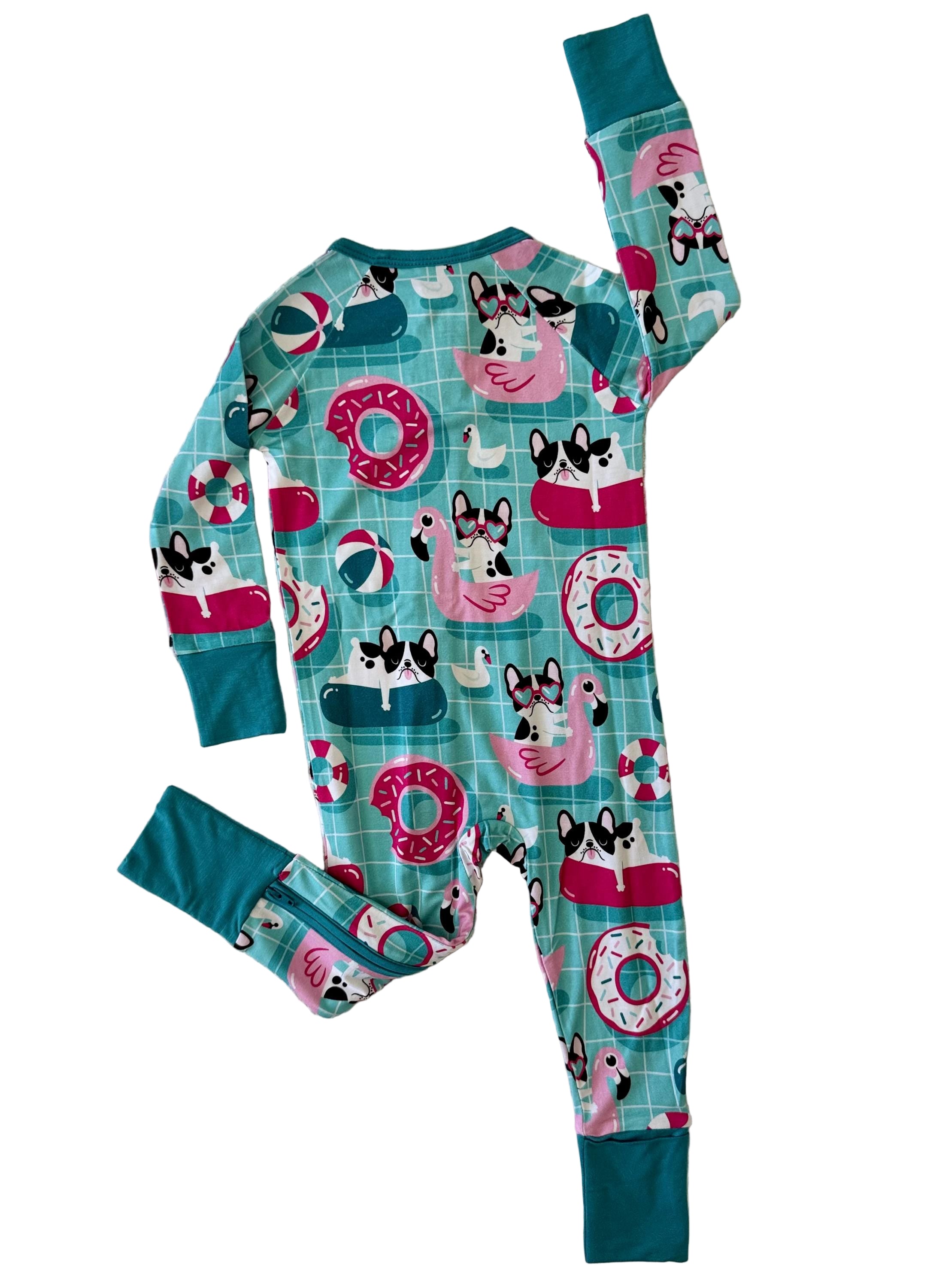 Super soft bamboo convertible footie pajamas with dogs having a pool party with flamingo and donut pool floats on blue background. 