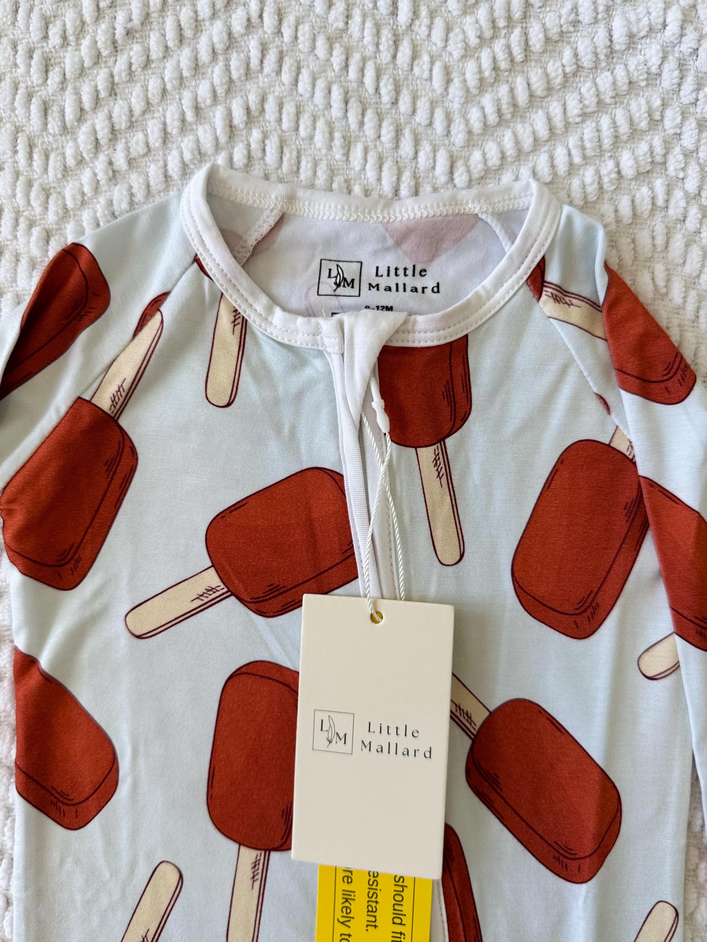 Breathable Baby onesie with popsicle pattern and Little Mallard tag on a textured white background