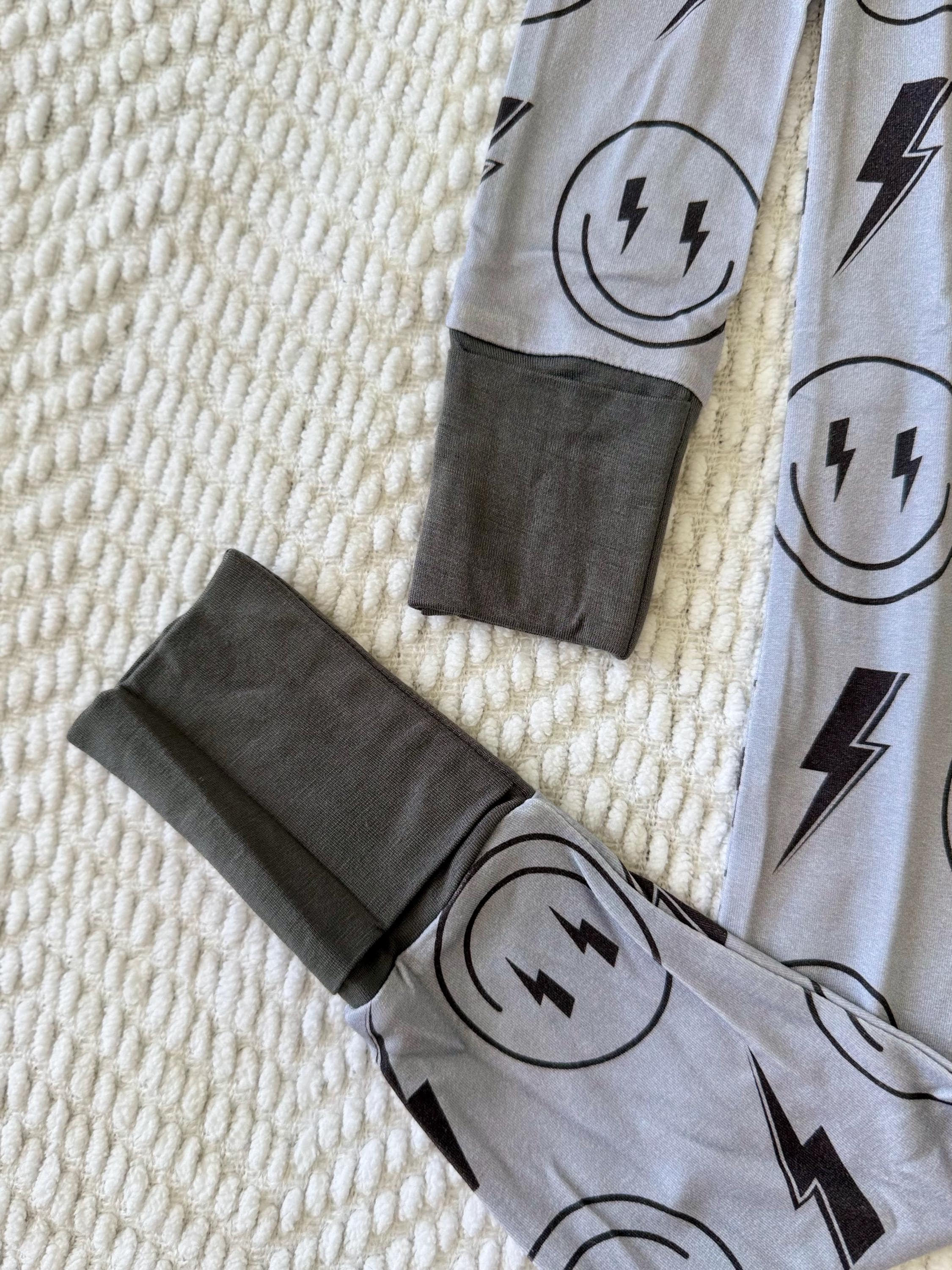 Super soft and breathable Gray baby pajama with black lightning bolt and smiley face patterns on a textured surface