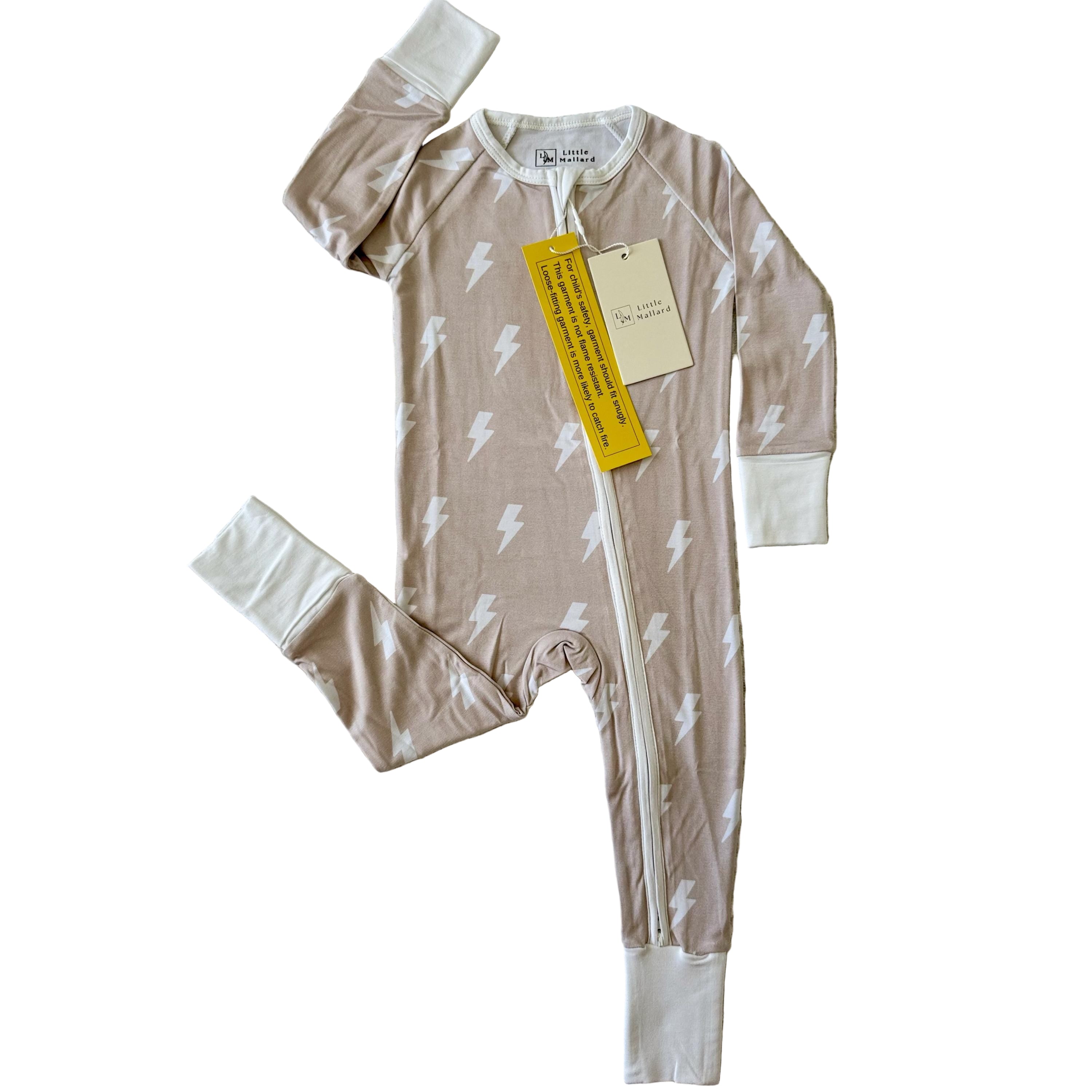 Gender neutral beige Baby convertible bamboo baby pajamas with white lightning bolt pattern on a white surface. 