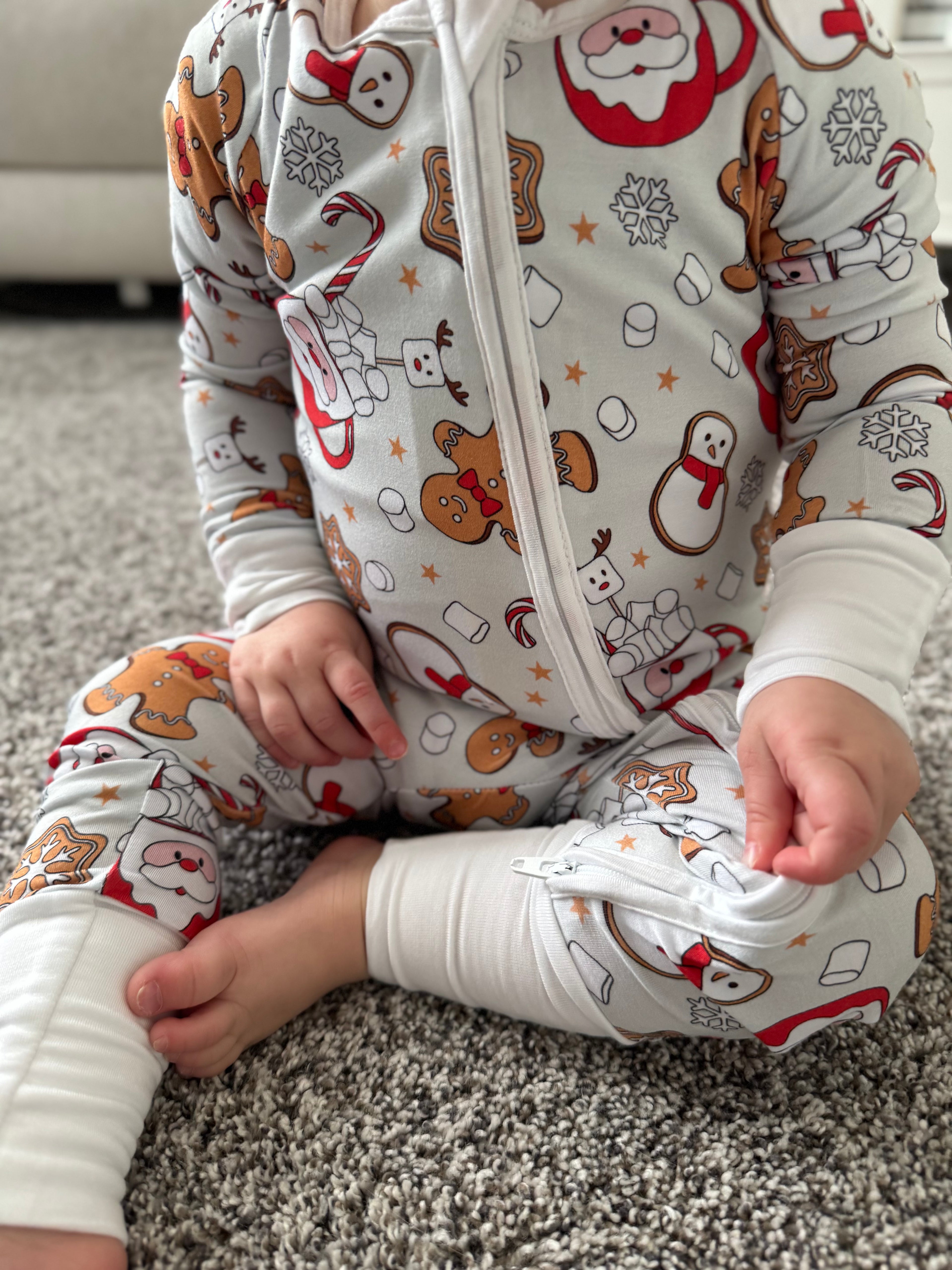 Baby wearing Bamboo christmas pajamas with Santa mug, candy canes, ginger bread cookies, marshmallows, snowflakes, cookies, snowman and more! The bamboo pajamas are so soft and great on sensitive skin. These footies have convertible mittens and footies to allow them to grow with your little one! Super soft romper, Soft onesie, soft sleeper, soft baby sleepwear. 