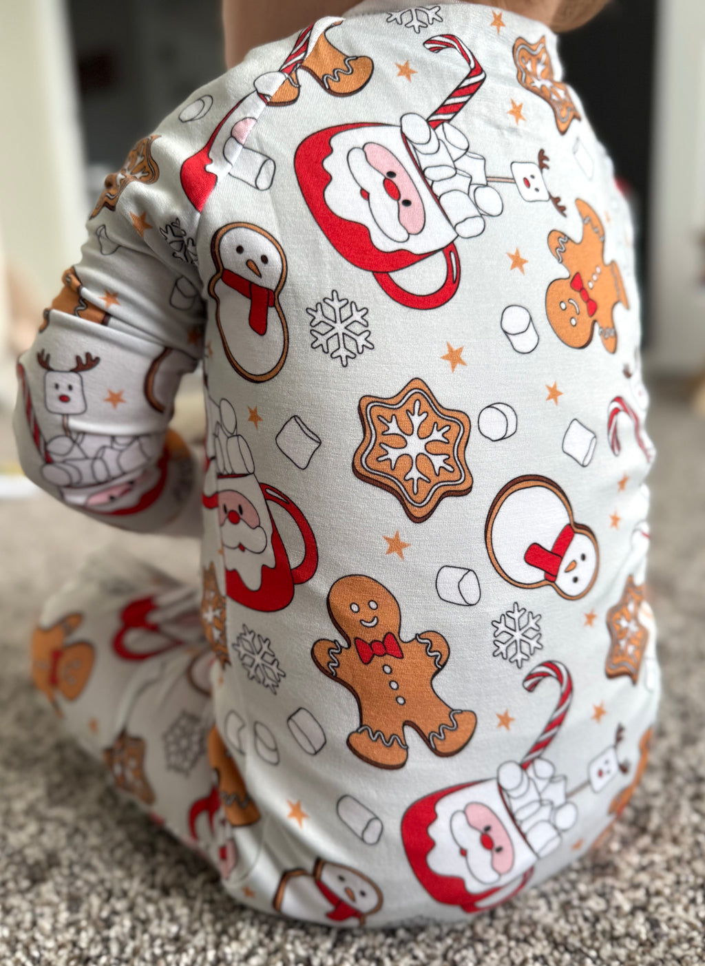 Toddler wearing Bamboo christmas pajamas with Santa mug, candy canes, ginger bread cookies, marshmallows, snowflakes, cookies, snowman and more! The bamboo pajamas are so soft and great on sensitive skin. These footies have convertible mittens and footies to allow them to grow with your little one! Super soft romper, Soft onesie, soft sleeper, soft baby sleepwear. 
