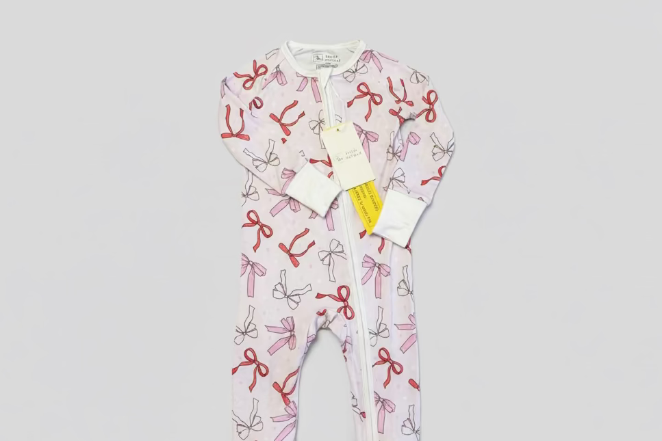 Valentine's Day Bamboo toddler and baby pajama. Pajama includes pale pink background with white, pink and red ribbon. Background also has multi color different stars. This Galentine's Day design is perfect for a baby girl or toddler girl! Especially perfect for your little one's first valentines day! Our bamboo pajama is soft, durable, breathable and comfortable. 