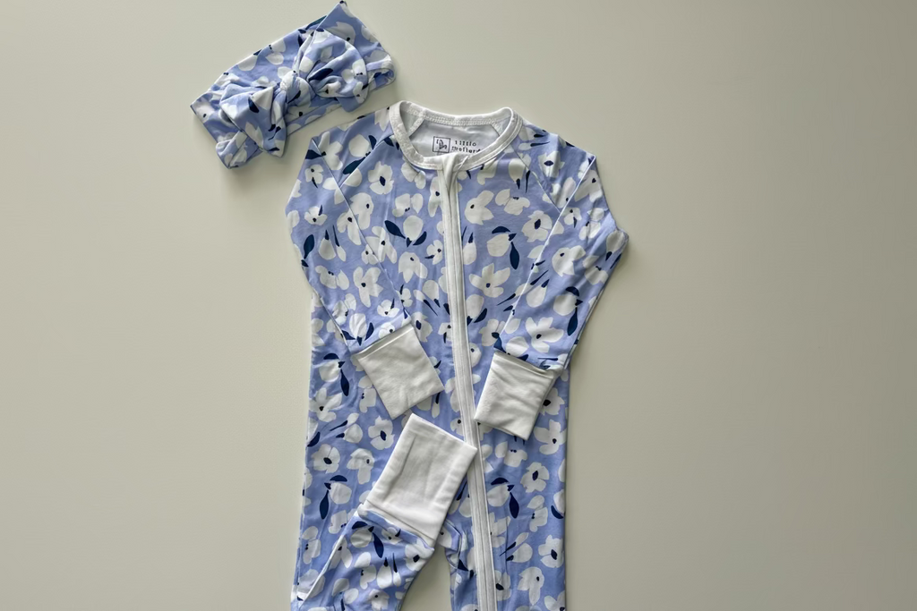 Baby onesie with floral pattern and matching bow head wrap. 