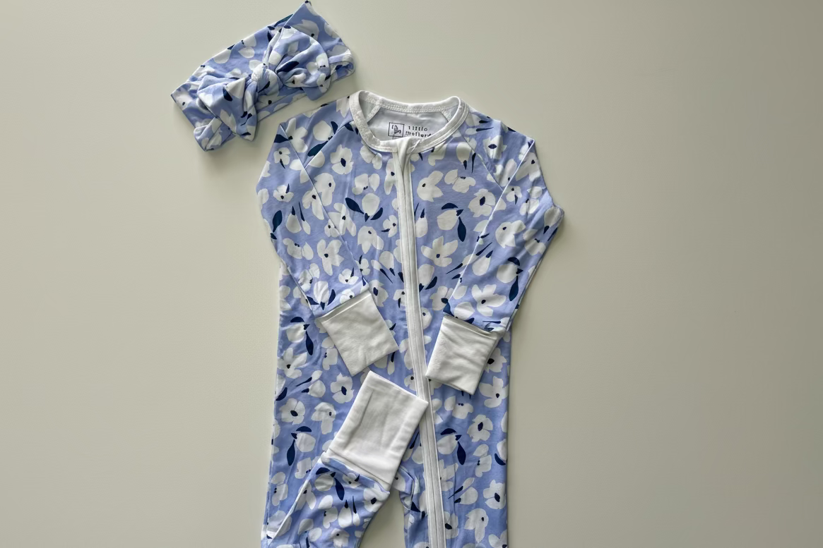 Baby onesie with floral pattern and matching bow head wrap. 